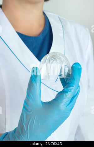 Blanchiment des dents, droite saine, bretelles amovibles dans la main du médecin, plateau de dents invisible Protecteur buccal, orthodontique adolescent, alignement dentaire clair Gu de nuit Banque D'Images