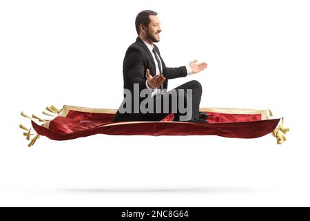 Photo d'un homme d'affaires volant sur un tapis de velours rouge isolé sur fond blanc Banque D'Images