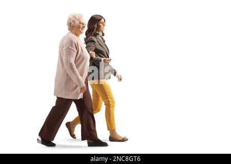 Femme âgée tenant une jeune femme sous le bras et marchant ensemble isolée sur fond blanc Banque D'Images