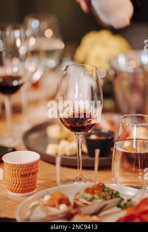 L'expérience de dégustation de vin dans la cave rustique et un bar à vin : Verre à vin rouge et collection d'excellents vins sur l'arrière-plan Banque D'Images