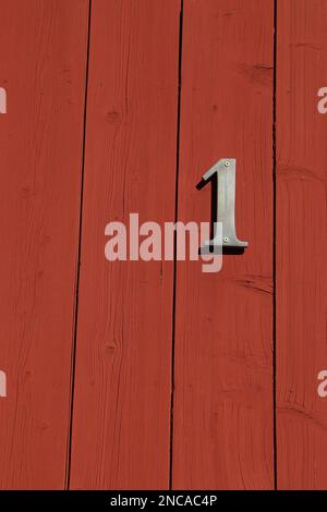 affiche blanche numéro un sur une porte rouge avec bandes horizontales, numéro de maison Banque D'Images