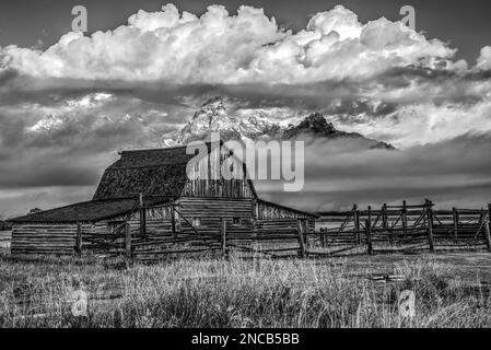 Image en noir et blanc de Molton Barn, parc national de Grand Teton, Wyoming, États-Unis, alors qu'une tempête se dégage des montagnes en arrière-plan Banque D'Images