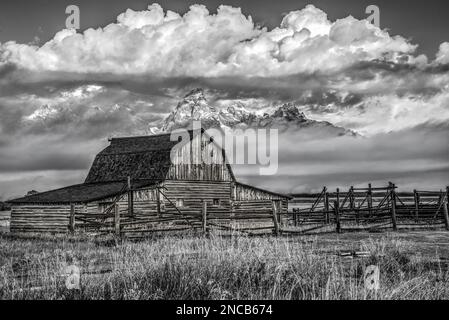 Image en noir et blanc de Molton Barn, parc national de Grand Teton, Wyoming, États-Unis, alors qu'une tempête se dégage des montagnes en arrière-plan Banque D'Images