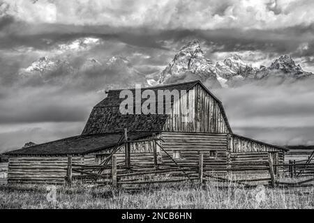 Image en noir et blanc de Molton Barn, parc national de Grand Teton, Wyoming, États-Unis, alors qu'une tempête se dégage des montagnes en arrière-plan Banque D'Images