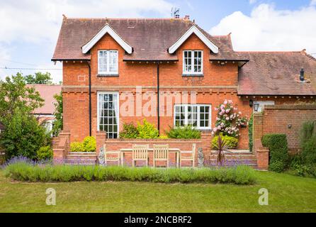 Grand manoir britannique et jardin avec pelouse et terrasse avec mobilier de jardin en teck Banque D'Images