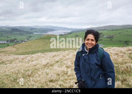 Femme indienne d'Asie britannique en manteau imperméable randonnée dans le parc national de Snowdonia près du lac Bala, au nord du pays de Galles, au Royaume-Uni Banque D'Images