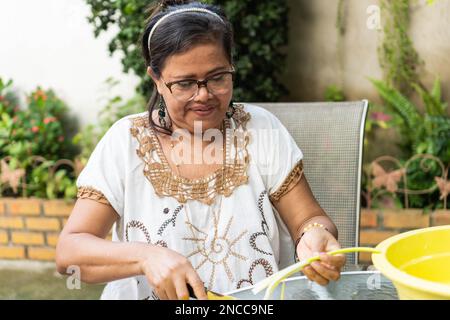 Senior Hispanic woman chopping légumes frais Banque D'Images