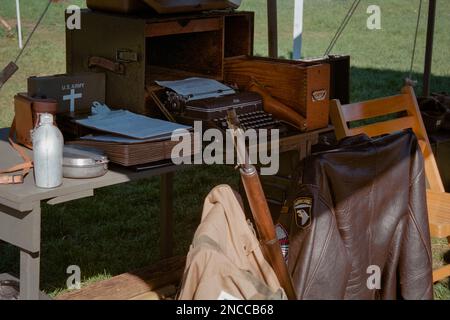 Une tente du secrétaire de la Seconde Guerre mondiale avec une machine à écrire, un fusil et une veste en cuir Airborne visible au premier plan lors d'une reconstitution au patrimoine américain Banque D'Images