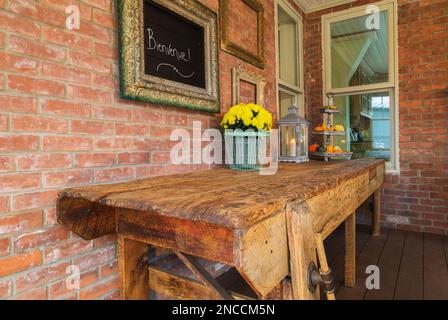 Ancien banc d'atelier en bois rustique usé et usé dans la véranda à l'arrière de l'ancienne maison victorienne de style renaissance de la reine Anne 1900, Québec, Canada. Cette image Banque D'Images