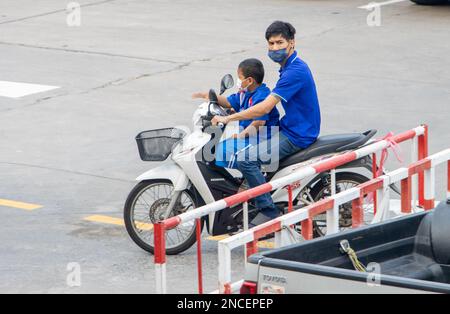 SAMUT PRAKAN, THAÏLANDE, FÉVRIER 03 2023, Un homme roule avec un garçon sur une moto. Banque D'Images