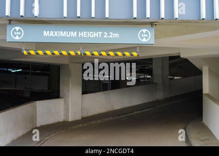 Affiche : hauteur maximale 2,2m, rouge et blanc, suspendue au plafond du parking Banque D'Images