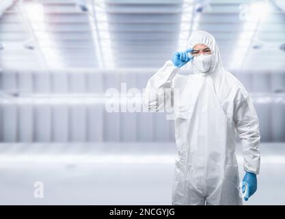 Le travailleur porte une combinaison de protection médicale ou une combinaison de combinaison blanche avec un masque et des lunettes de protection Banque D'Images