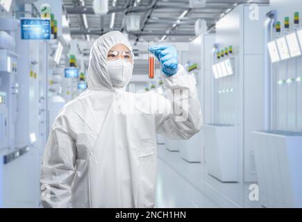 Le travailleur porte une combinaison de protection médicale ou une combinaison de combinaison blanche avec tube à essai en laboratoire Banque D'Images