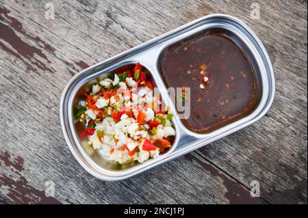 sauce chili à l'ail, délicieuse sauce trempée à l'ail sur une tasse sur fond de nourriture de table en bois Banque D'Images