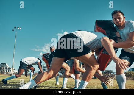 Il faut du travail dur pour devenir l'un des meilleurs. un groupe de joueurs de rugby s'entraîne avec des sacs à main sur le terrain. Banque D'Images