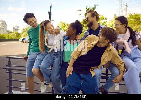 Joyeux multiethnique jeune homme et femme amis différentes races et nationalités posant à l'extérieur Banque D'Images