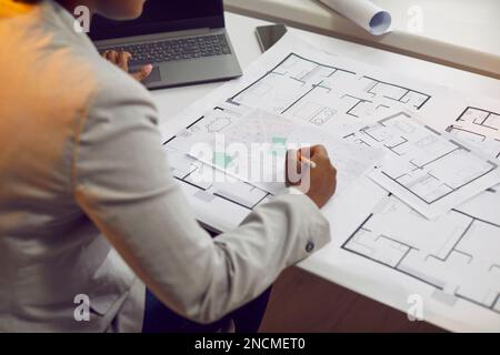 Femme architecte travaillant sur des plans et utilisant des plans urbains et des cartes cadastrales de la ville Banque D'Images