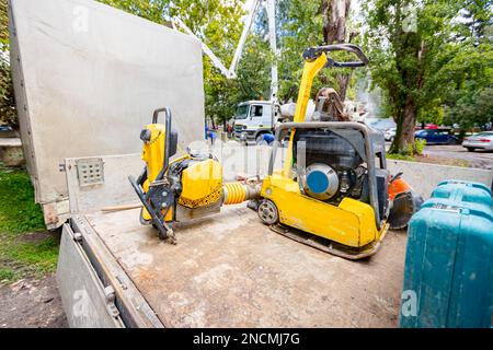 Un compacteur à plaque, un marteau vibrant debout et une machine de tassage à cric rouleur ont été placés sur la remorque du camion. Outils électriques sur le chantier. Banque D'Images
