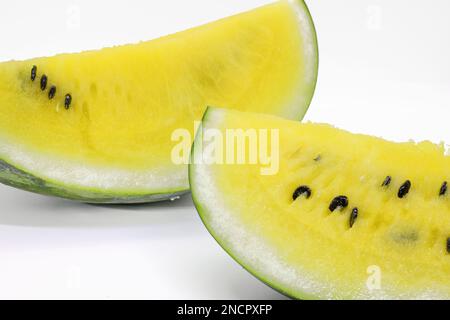 gros plan de quelques morceaux de pastèque rafraîchissante sur fond blanc, pastèque jaune avec feuilles de menthe et morceaux de glace, nourriture Banque D'Images