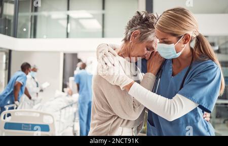 Médecin, hug et triste femme âgée à l'hôpital pour le soutien, le confort et l'empathie pour la chirurgie du mari. Medic, masque facial et embrasser la femme du patient Banque D'Images
