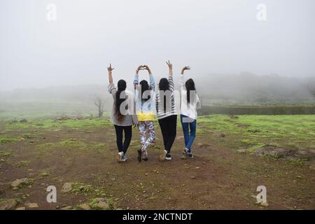 MAHAARRSHTRA, PUNE, LONAVALA, août 2022, Groupe de jeunes filles indiennes en couleur-ensembles décontractés appréciant la nature, face à l'arrière montrant main si Banque D'Images