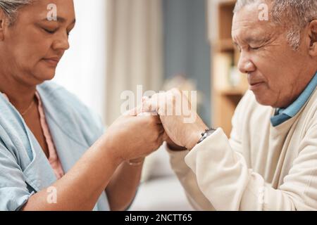 Bible, prier ou vieux couple tenant les mains ensemble dans une maison chrétienne en retraite avec espoir ou foi. Jésus, religion ou croyance avec un homme âgé Banque D'Images