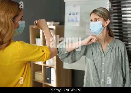 Les gens se saluent en heurtant les coudes au lieu de se serrer la main à l'intérieur Banque D'Images