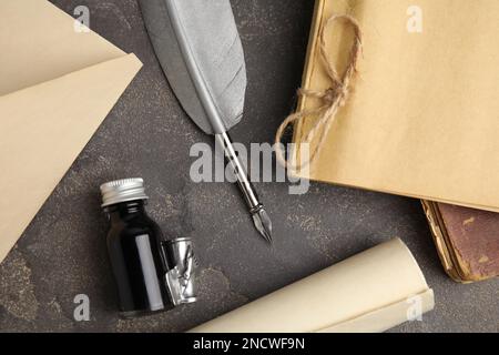 Composition de pose plate avec stylo plume et bouteille d'encre sur table grise Banque D'Images