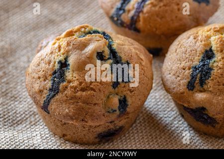Muffins aux myrtilles faits maison sur fond de texture hessienne gros plan avec l'espace de copie Banque D'Images