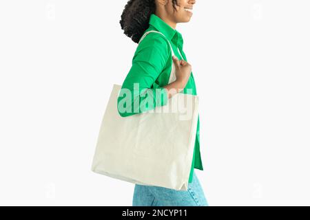 Femme noire méconnue portant un cabas en textile sur fond blanc Banque D'Images