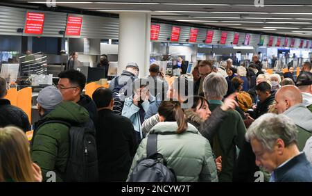 15 février 2023, Hesse, Francfort-sur-le-main : de nombreux passagers font la queue devant un bureau d'information Lufthansa situé dans le terminal 1 de l'aéroport de Francfort. En raison d'une panne INFORMATIQUE au sein du groupe Lufthansa, des milliers de passagers ont été affectés par des retards et des annulations de vols mercredi (15.02.2023 ). Photo: Arne Dedert/dpa Banque D'Images