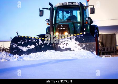 Tracteur Fendt équipé d'un chasse-neige déneigement par jour d'hiver, vue avant. Salo, Finlande. 11 février 2023. Banque D'Images