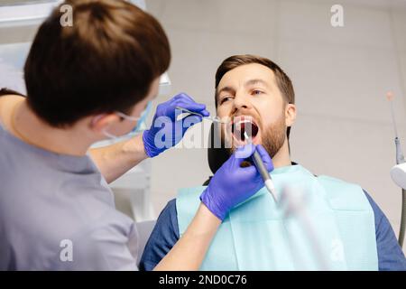 Homme ayant des dents examinées chez les dentistes. Aperçu de la prévention des caries dentaires. Banque D'Images