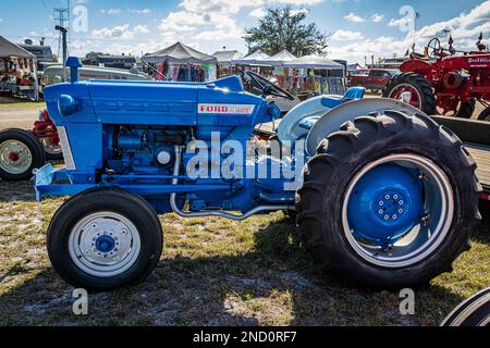 Fort Meade, FL - 24 février 2022 : vue latérale en haute perspective d'un tracteur utilitaire Ford 300 1965 lors d'un salon de tracteur local. Banque D'Images