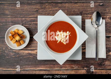 Soupe de tomates avec fromage dans un bol en porcelaine blanche Banque D'Images