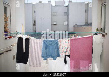 Linge suspendu sur des cordes, séchage à l'air sous la lumière du soleil dans la cour du bâtiment résidentiel Banque D'Images