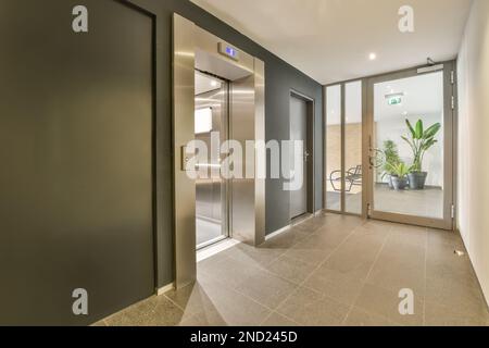 Décoration intérieure de couloir moderne avec ascenseur et porte en verre dans un immeuble contemporain Banque D'Images