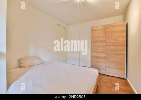 Décoration intérieure de chambre minimaliste avec murs blancs, grand lit et parquet Banque D'Images