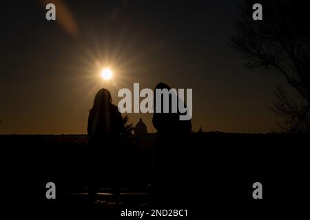 Rome, Italie. 14th févr. 2023. Les couples regardent le coucher du soleil depuis la promenade près de Pincio Terrace le jour de la Saint-Valentin, avec St. Peter's Dome en arrière-plan. (Photo de Matteo Nardone/Pacific Press) crédit: Pacific Press Media production Corp./Alay Live News Banque D'Images