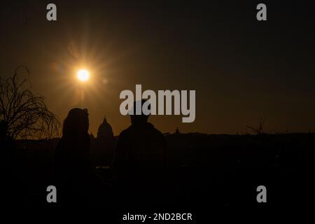 Rome, Italie. 14th févr. 2023. Les couples regardent le coucher du soleil depuis la promenade près de Pincio Terrace le jour de la Saint-Valentin, avec St. Peter's Dome en arrière-plan. (Photo de Matteo Nardone/Pacific Press) crédit: Pacific Press Media production Corp./Alay Live News Banque D'Images