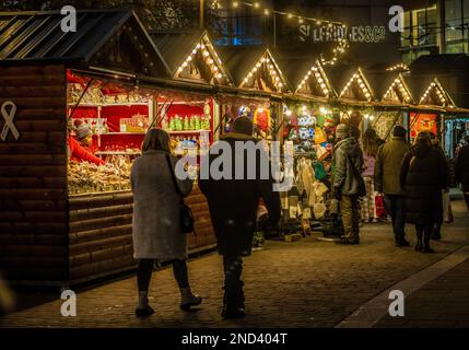 Étals de type chalet alpin en bois devant Selfridges sur la place Exchanger la nuit. Marchés de Noël de Manchester. Manchester. ROYAUME-UNI Banque D'Images