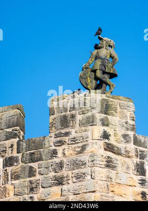 Figure en pierre sculptée au-dessus du portier du château d'Alnwick, Northumberland, Angleterre, Royaume-Uni Banque D'Images