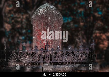 la pierre tombe derrière une clôture en métal rouillé Banque D'Images