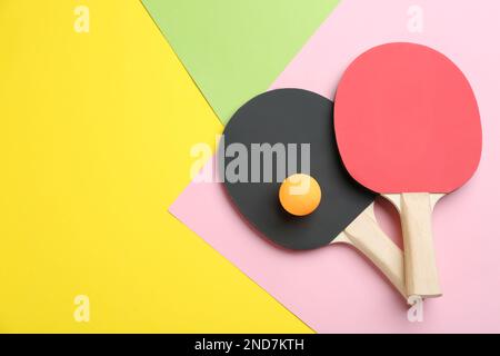 Raquettes de ping-pong et balle sur fond de couleur, plat. Espace pour le texte Banque D'Images