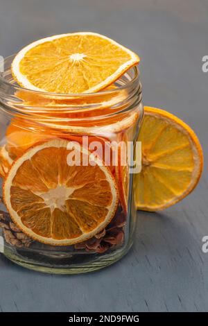 Tranches d'orange dans un pot en verre. Gros plan. Arrière-plan gris. Banque D'Images