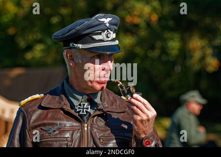 Un officier allemand en veste de cuir fumant un tuyau sur le champ de bataille lors d'une reconstitution au Musée du patrimoine américain. Hudson, Massachusetts Banque D'Images