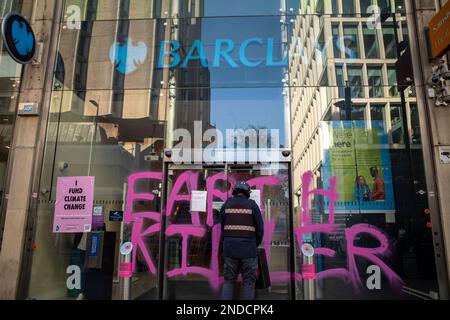 Les militants pour le changement climatique peignent des graffitis « Earth Killer » sur Barclays Bank, succursale de Tottenham court Road, Londres, février 2023. Rébellion de l'extinction. Banque D'Images