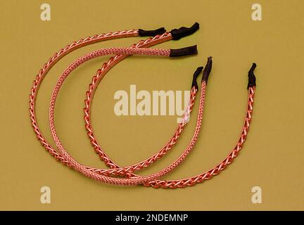 Accessoires de beauté de bandes de cheveux métalliques de couleur or isolés sur le jaune Banque D'Images