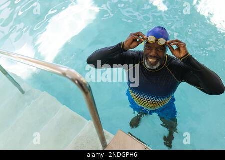 Portrait d'un homme senior afro-américain portant des lunettes de natation dans la piscine. concept de vie et de vie senior retraite Banque D'Images