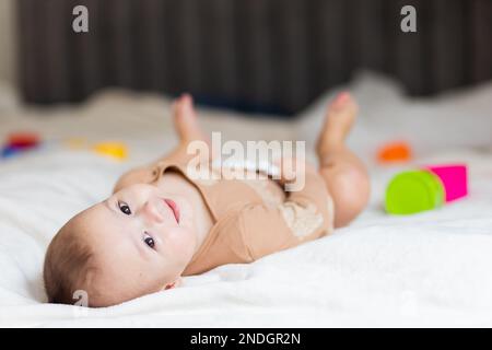 bébé jusqu'à un an, allongé sur le lit parmi les jouets Banque D'Images